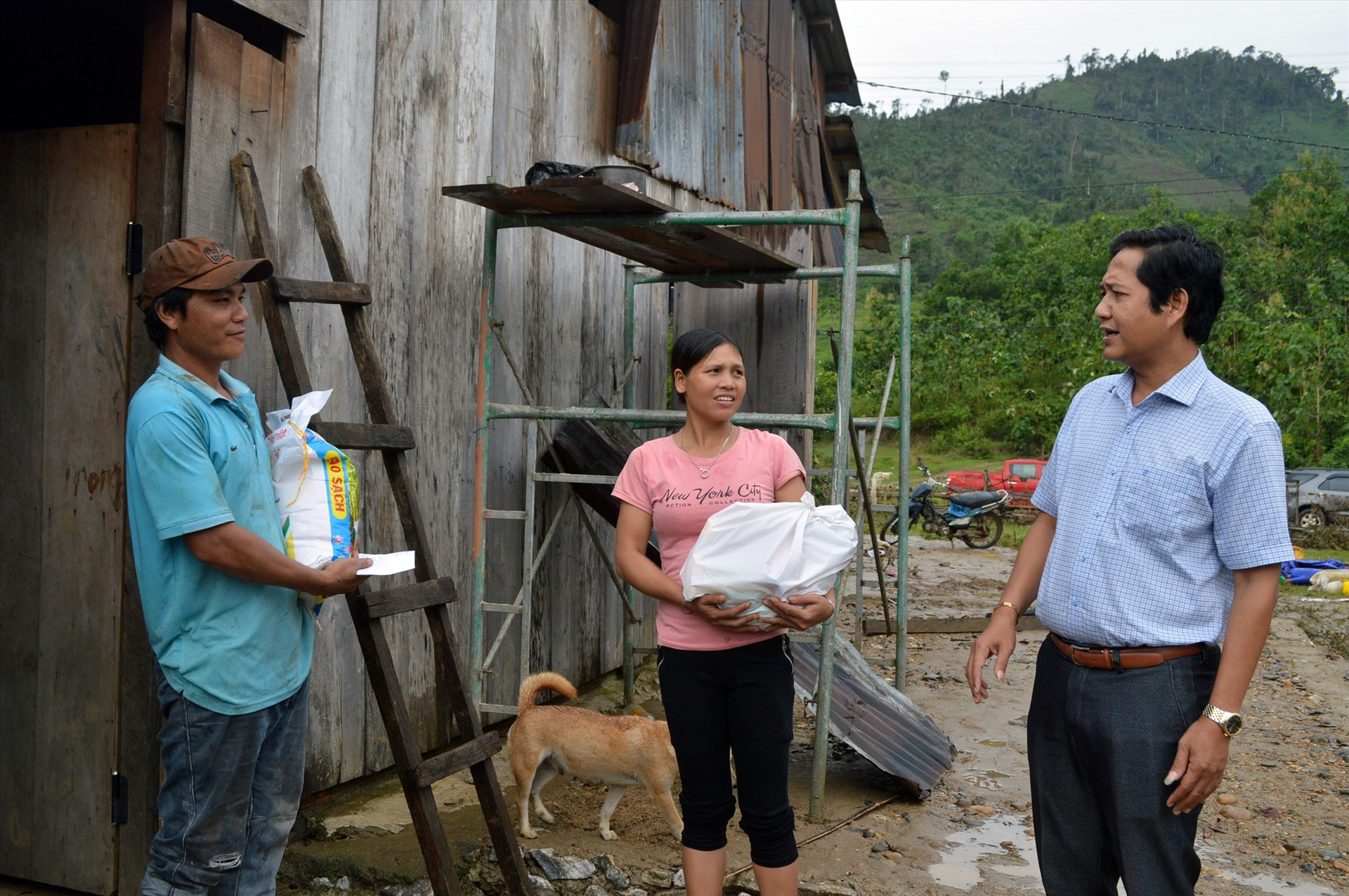 Ông A Viết Sơn (ngòai cùng bên phải) đến thăm và trao quà cho người dân bị thiệt hại do bão lũ