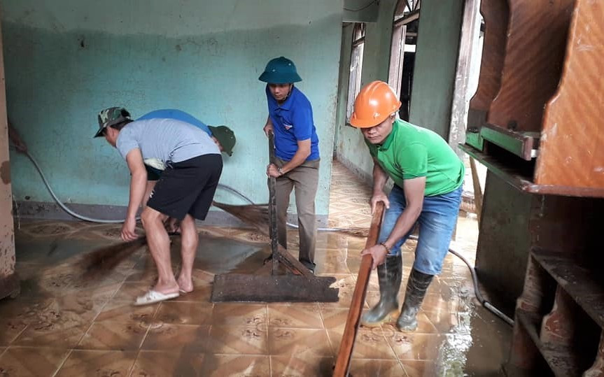 Thanh niên huyện Nam Giang giúp dân dọn bùn non tại thôn Bến Giằng (thị trấn Thạnh Mỹ). Ảnh: Huyện đoàn Nam Giang