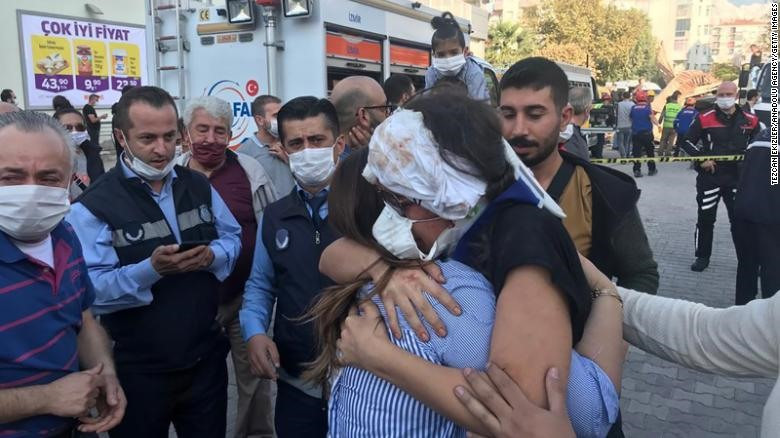 Người thân ôm chồng nạn nhân bị thương và may mắn sống sót sau động đất. Ảnh: Reuters