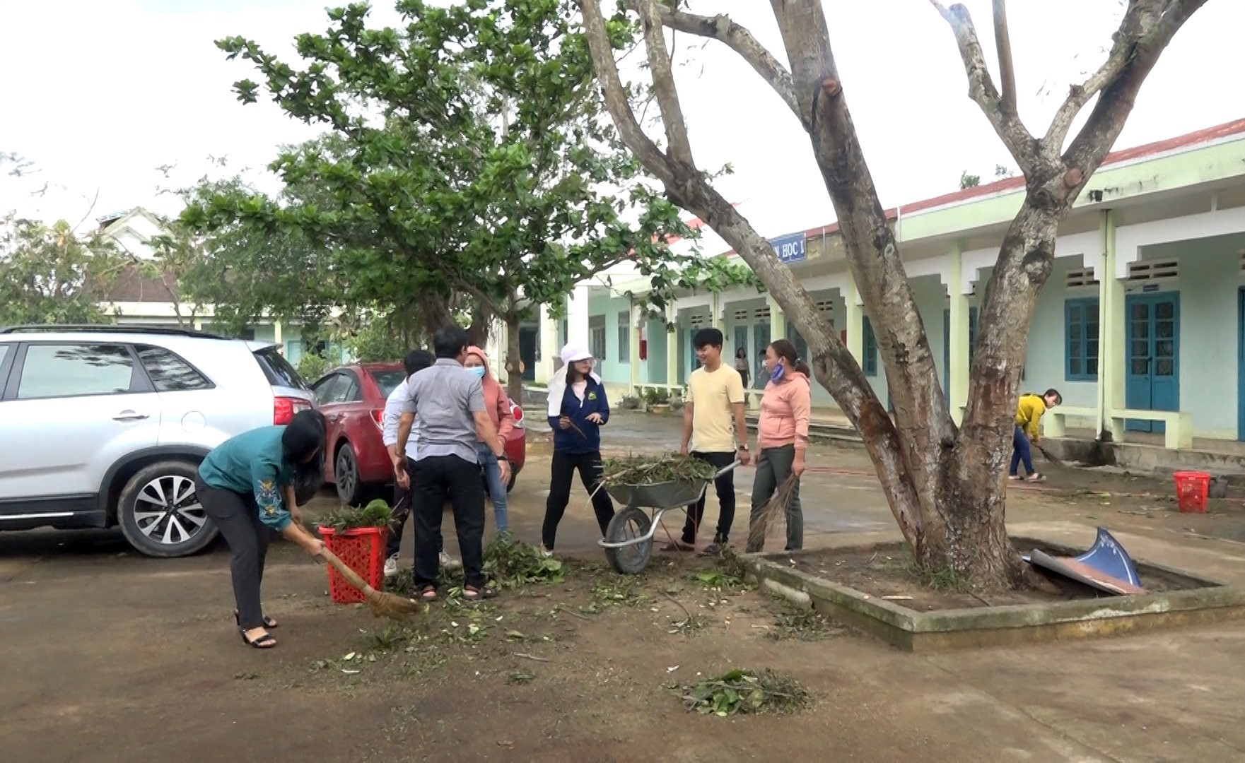 Các thầy, cô giáo và phụ huynh trường TH Võ Thị Sáu (Bình An) khẩn trương dọn vệ sinh để đón học sinh đi học trở lại. Ảnh: M.T