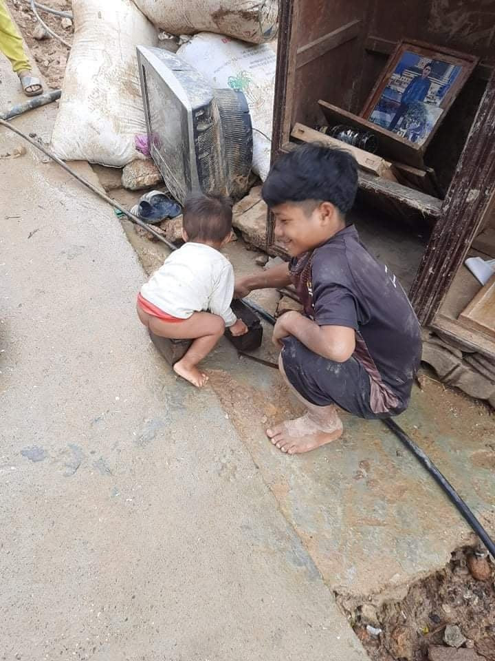 Hai em nhỏ ở xã Phước Thành bên những gì còn sót lại sau trận lũ quét. Ảnh: THU HÀ
