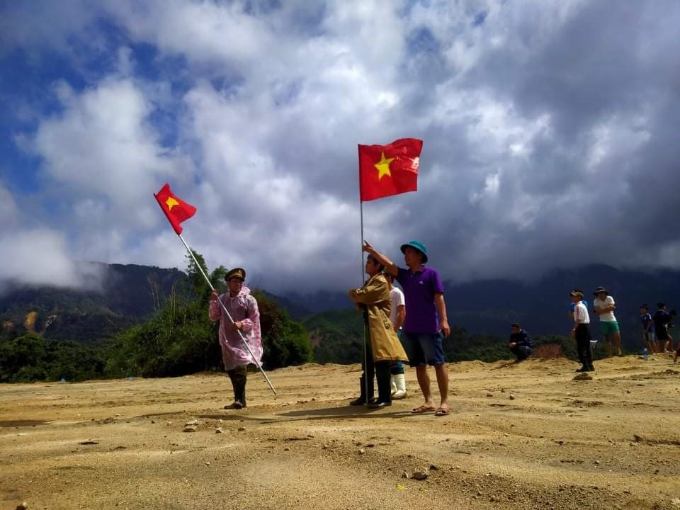 Người dân xã Phước Lộc dùng cờ Tổ quốc để đánh dấu địa điểm thả hàng cho trực thăng nhận diện. Ảnh: X.K