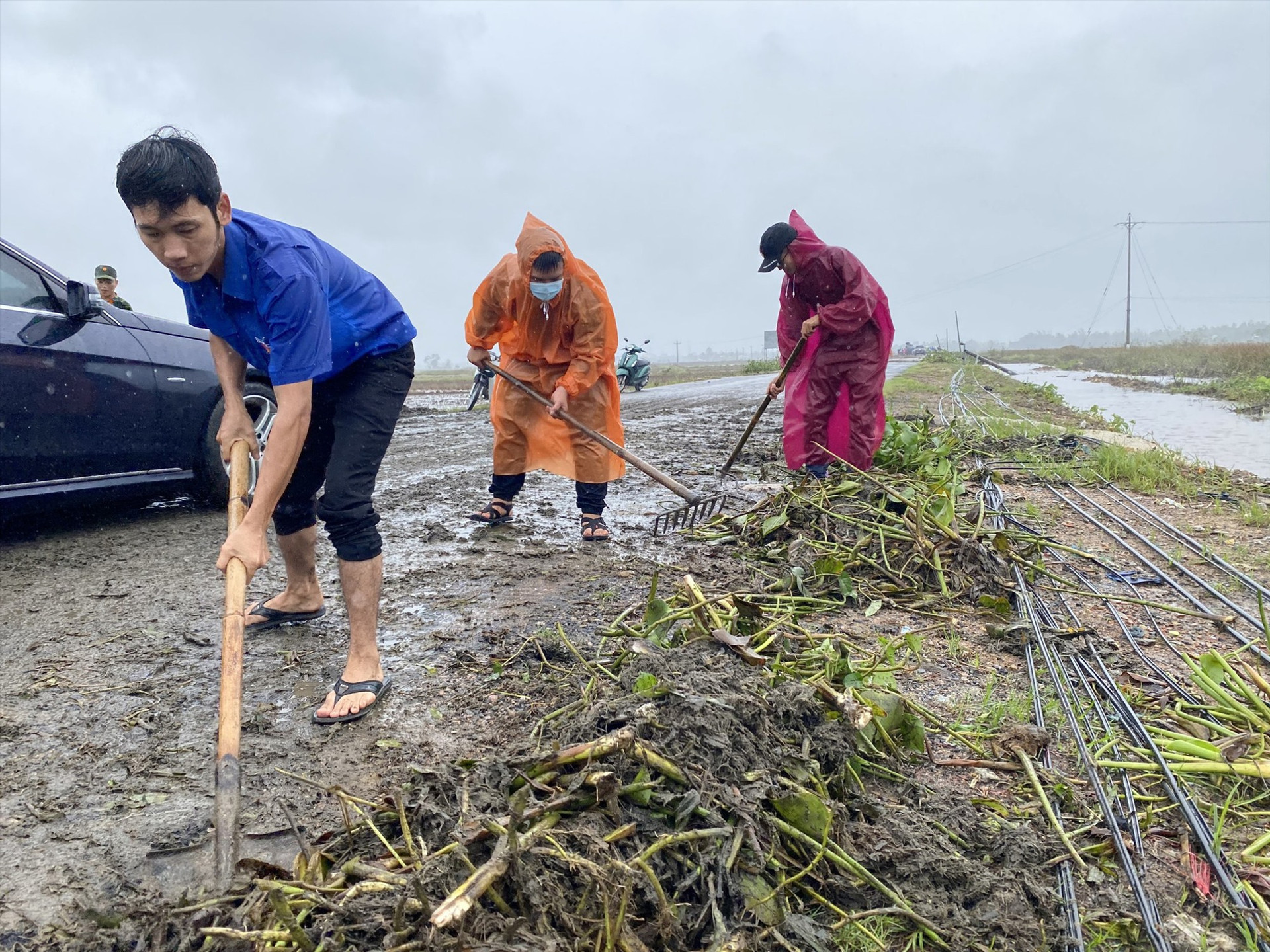 Đoàn viên thanh niên Điện Bàn dọn vệ sinh trên tuyến ĐT608 sau bão số 9. Ảnh: C.T