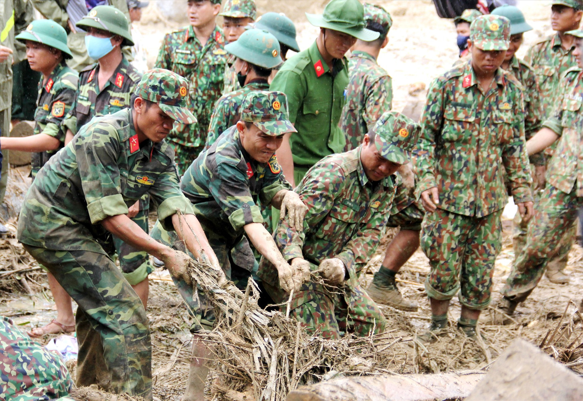 Các chiến sĩ dầm mưa tìm kiếm nạn nhân mất tích ở xã Trà Leng (Nam Trà My). Ảnh: NGƯỚC ANH