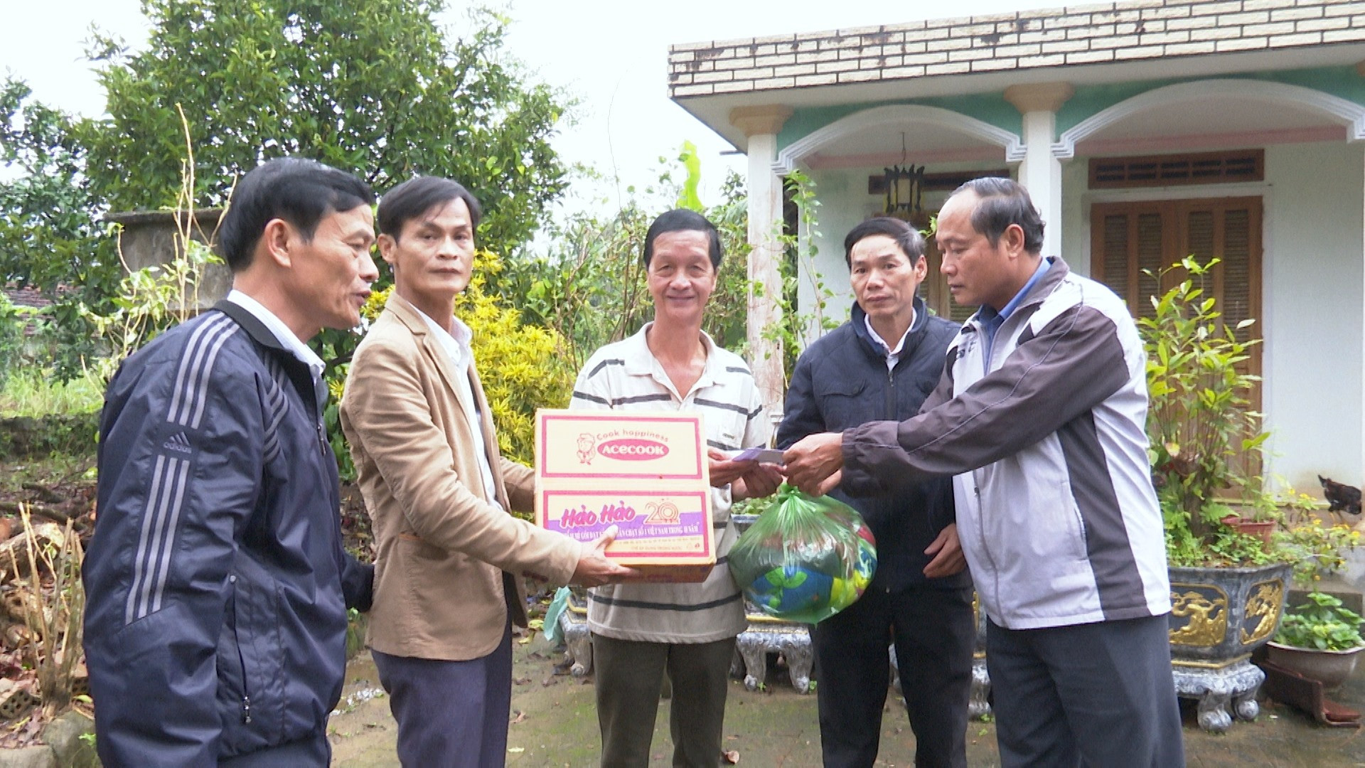 Lãnh đạo Huyện ủy Tiên Phước tặng quà cho một số chủ vườn cây ăn quả bị thiệt hại nặng do bão số 9. Ảnh: N.HƯNG