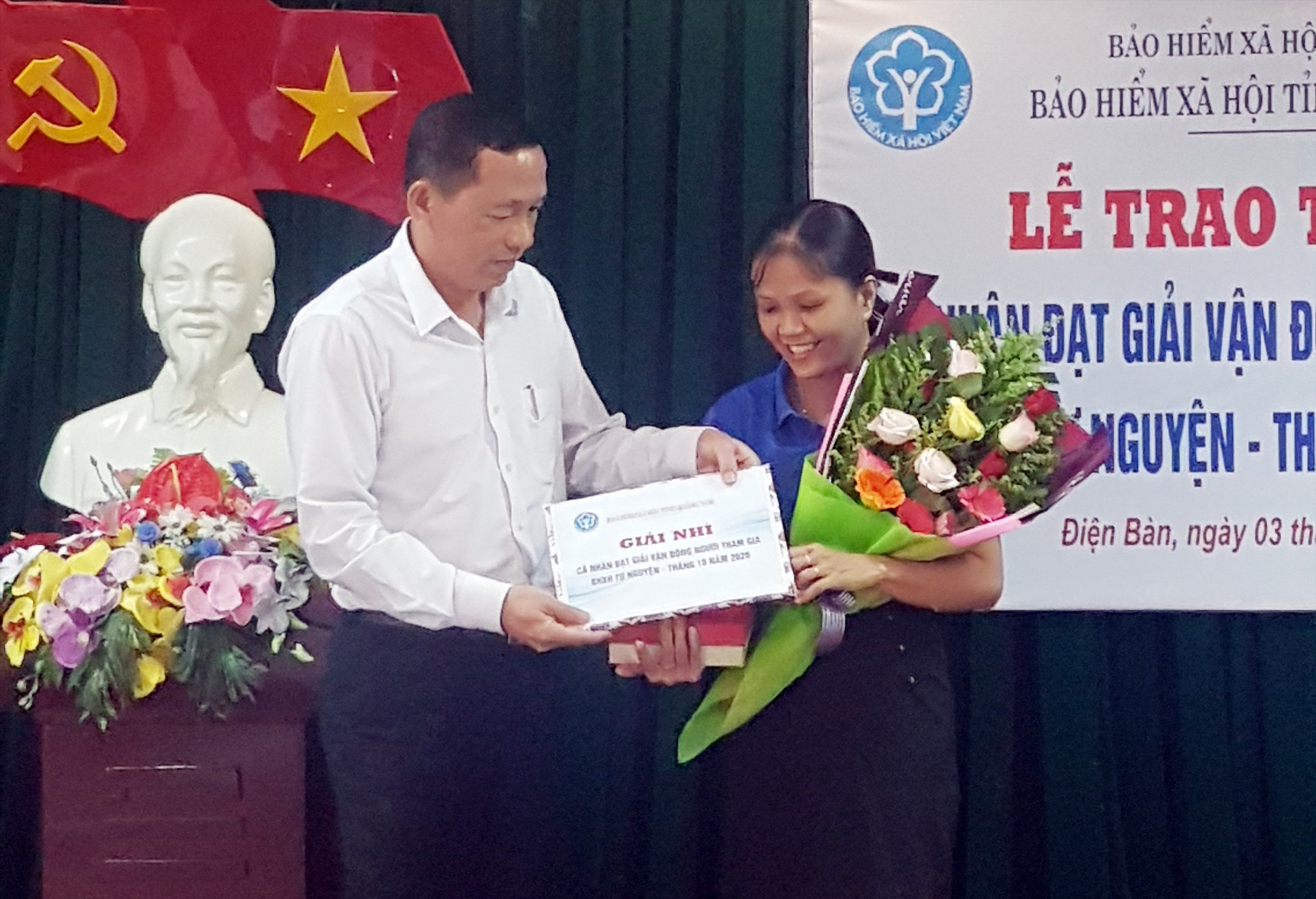 Giám đốc BHXH tỉnh Nguyễn Thanh Danh tặng giải thưởng động viên cho đại lý thu xuất sắc Hồ Thị Dũng. Ảnh: D.L