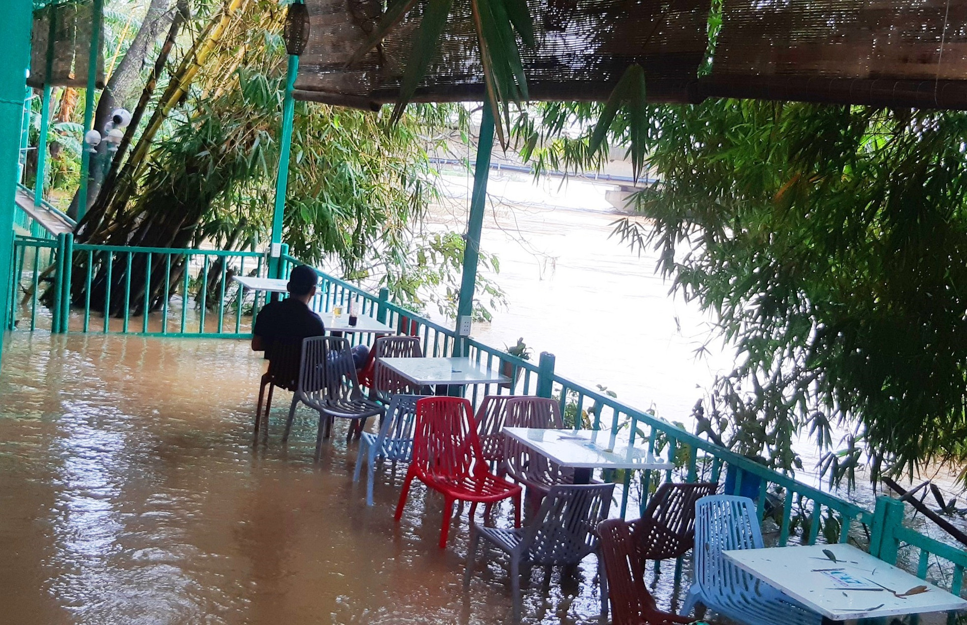 Nước lũ đã tràn lên một quán cà phê ven sông Vu Gia tại cầu Ái Nghĩa. Ảnh: HOÀNG LIÊN