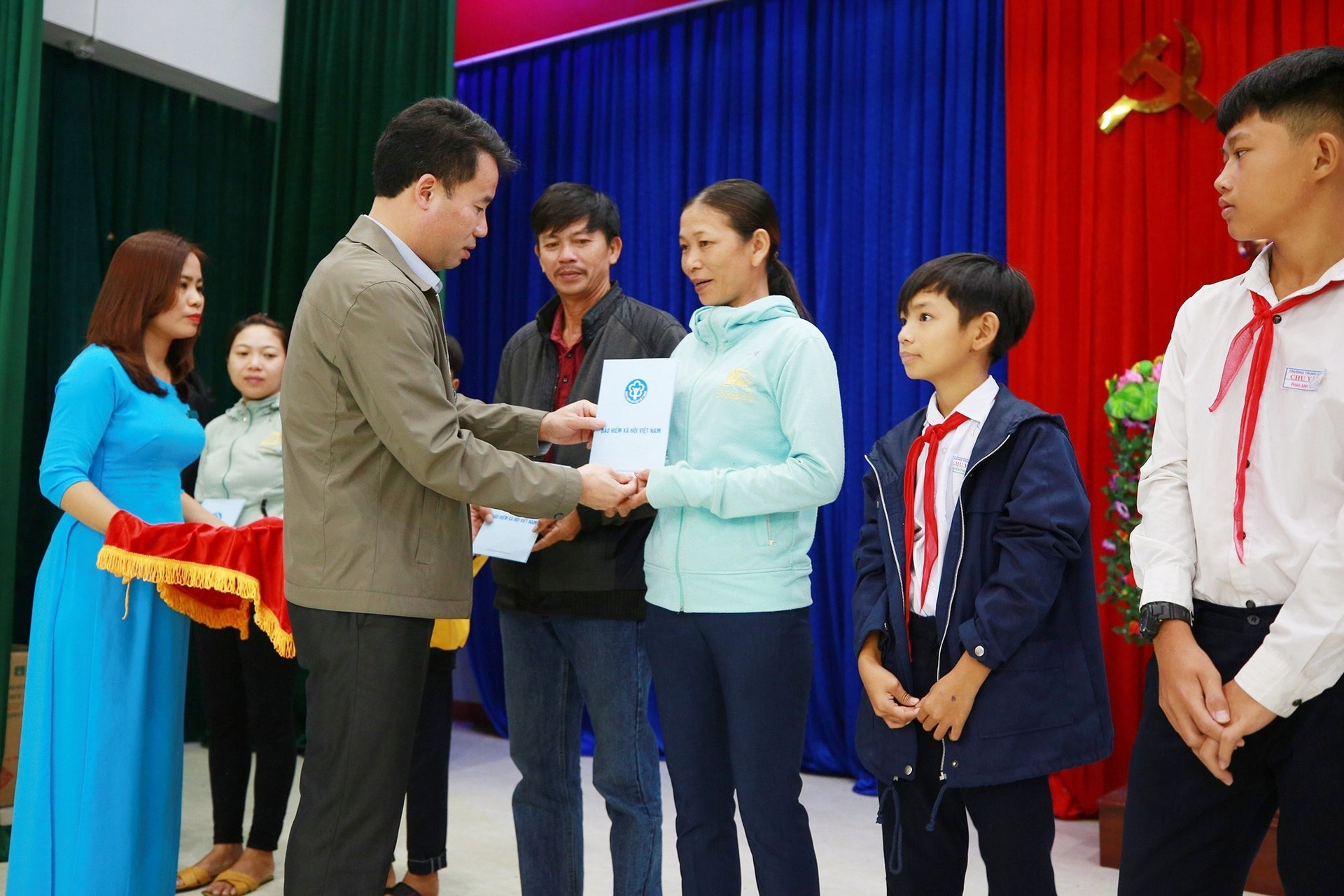 Tổng Giám đốc BHXH Việt Nam Nguyễn Thế Mạnh tặng thẻ BHYT cho người dân khó khăn ở huyện Thăng Bình. Ảnh: D.L