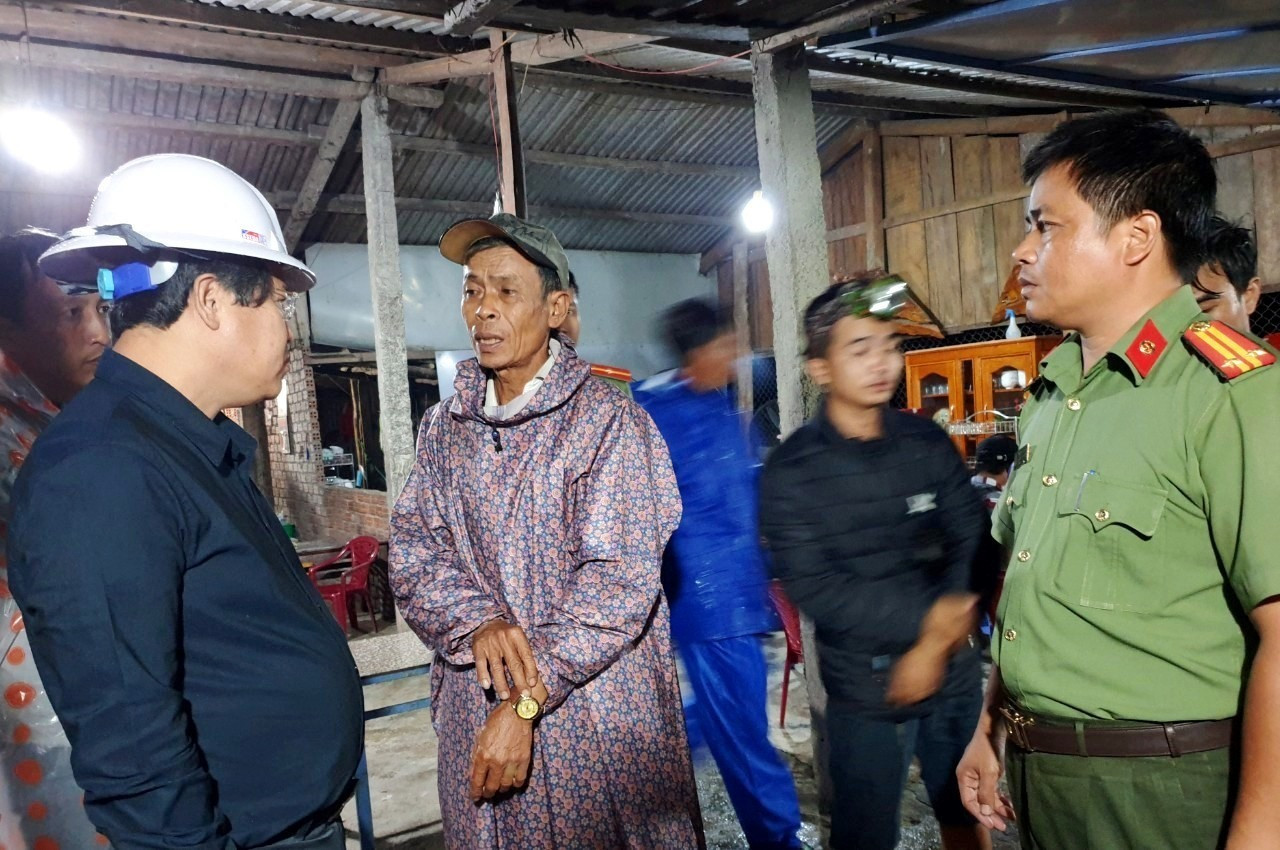 Ông Văn Anh Tuấn (bên trái) nói chuyện với người nhà của nạn nhân bị mất tích do sạt lở đường QL40B tại Trà Tân. Ảnh: CT