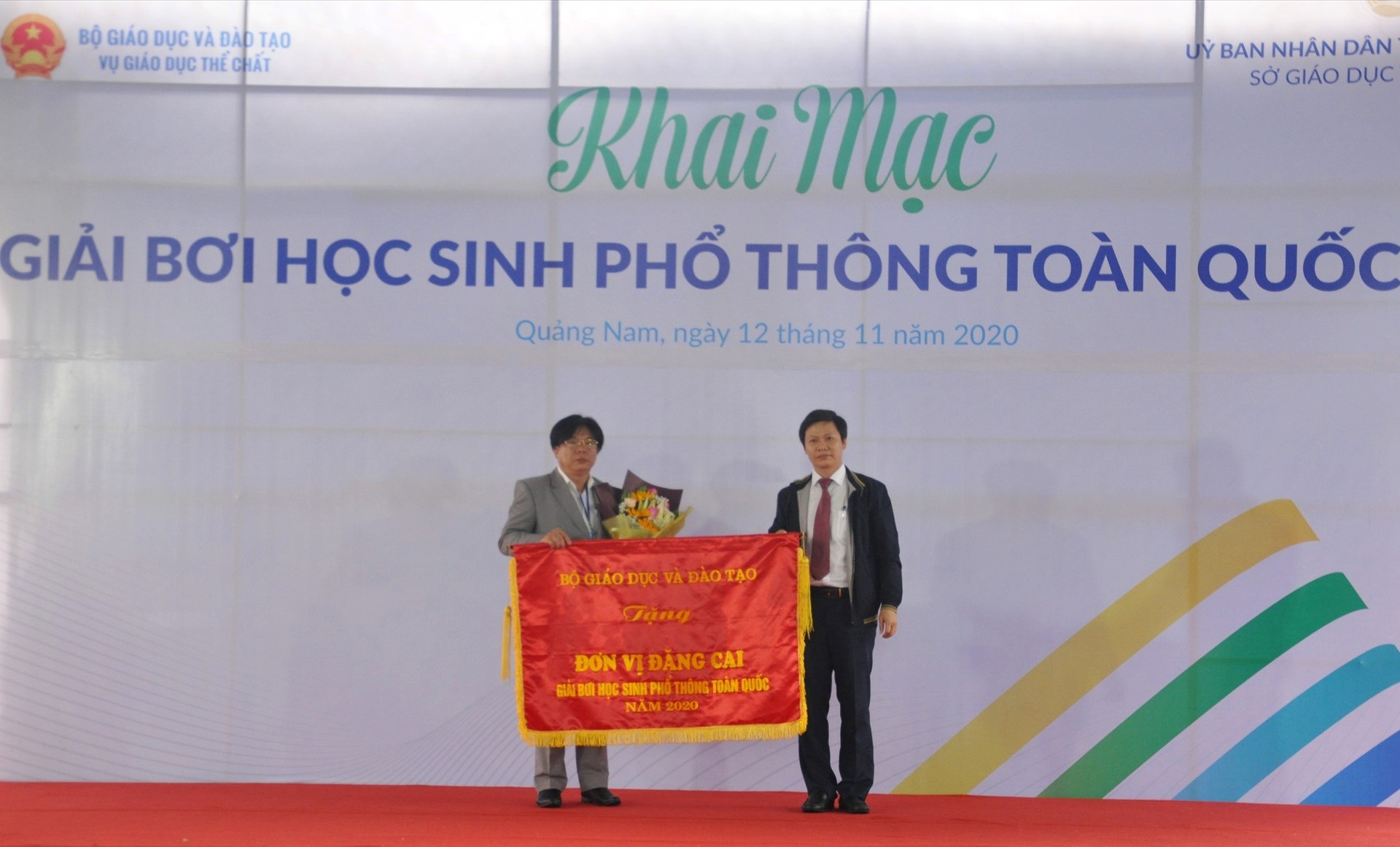 Vụ trưởng Vụ Giáo dục thể chất Bộ GD-ĐT Nguyễn Thanh Đề tặng cờ đăng cai cho Sở GD-ĐT Quảng Nam. Ảnh: X.P