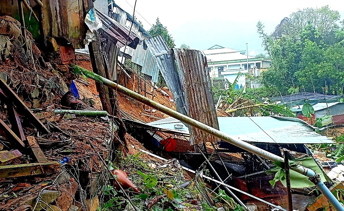 Sạt lở đất khiến nhiều ngôi nhà của người dân ở trung tâm xã  A Tiêng (Tây Giang) bị sụp đổ phía sau. Ảnh: A.N