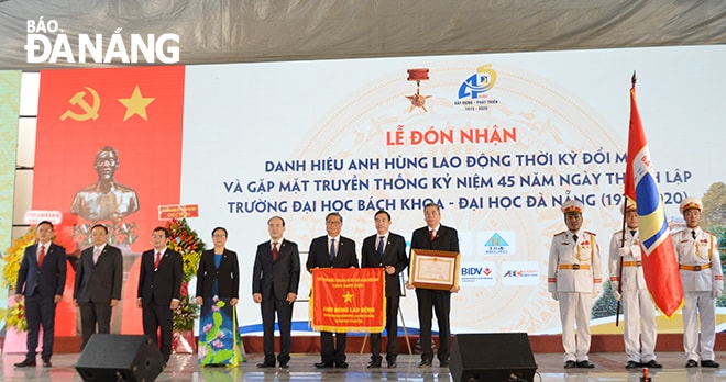 Thừa ủy quyền của Chủ tịch nước, Phó Chủ tịch Thường trực UBND thành phố Lê Trung Chinh (thứ 5 từ phải sang) trao Danh hiệu Anh hùng lao động thời kỳ đổi mới cho Ban giám hiệu Trường Đại học Bách khoa. Ảnh: NGỌC PHÚ
