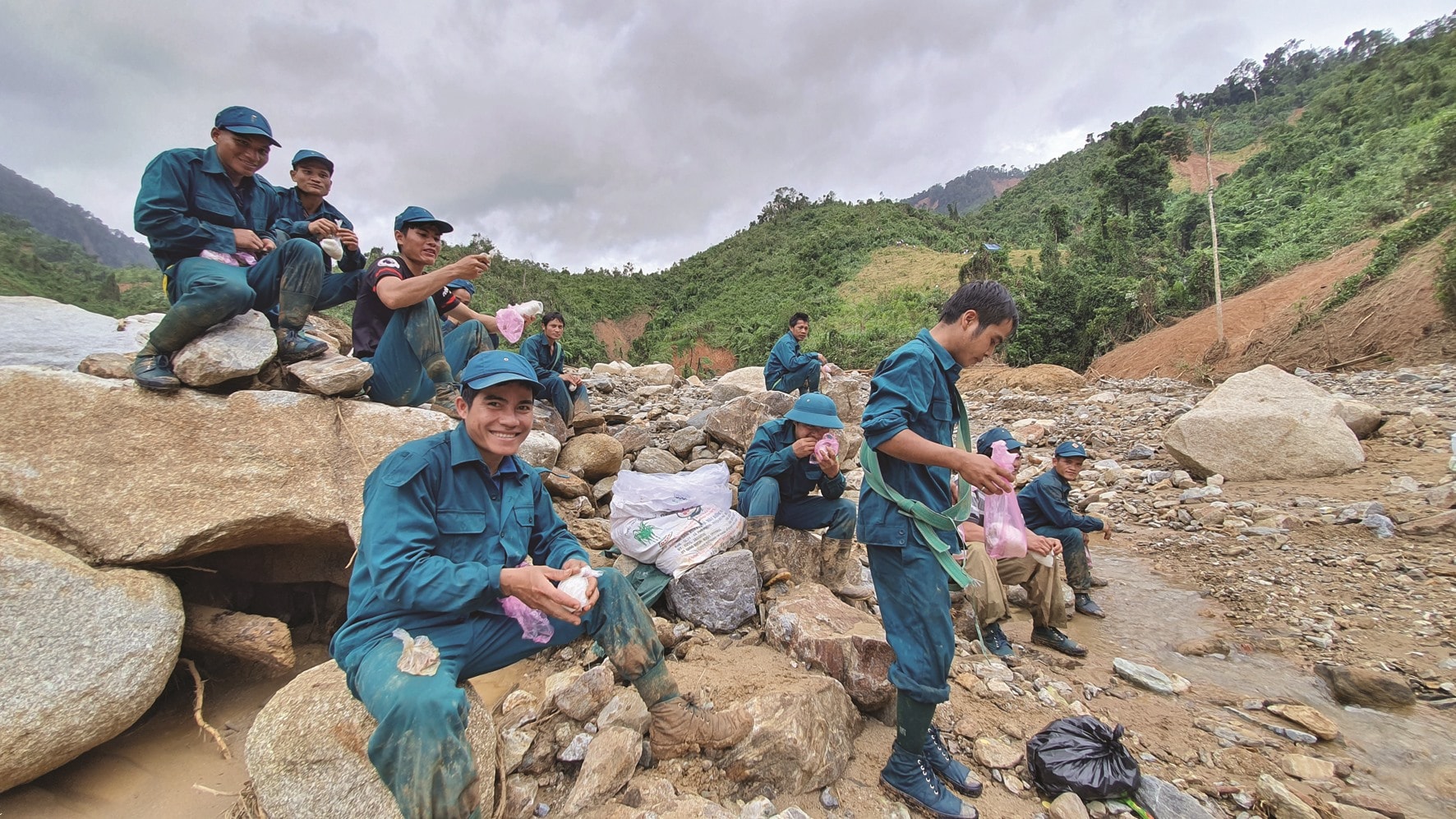 Bữa trưa của lực lượng dân quân xã Phước Kim gùi cõng hàng chi viện cho Phước Thành chỉ có nắm cơm và một ít cá khô, ngay bên lòng sông Trà Văn. Ảnh: G.C