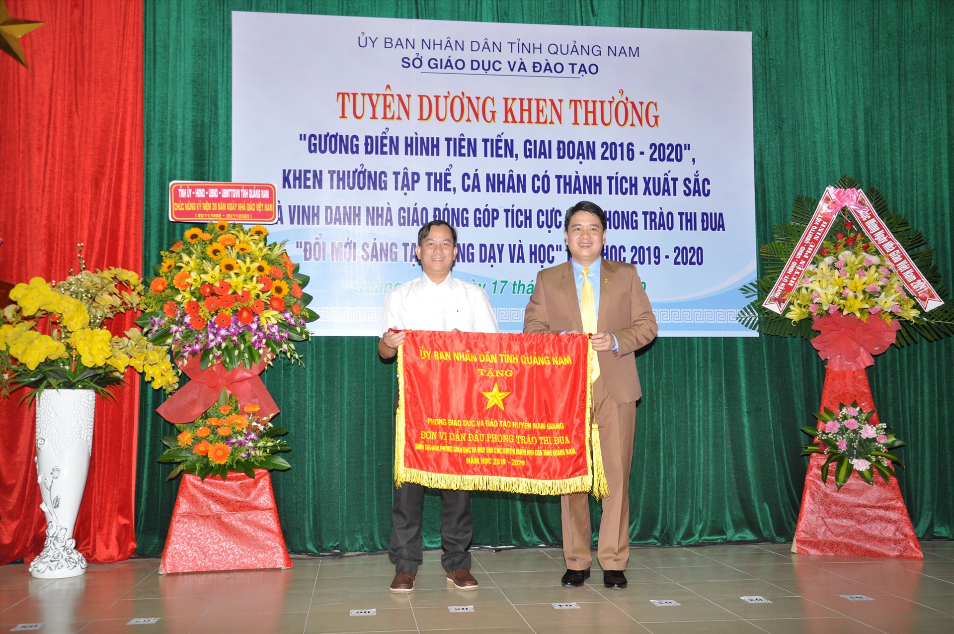 Phó Chủ tịch UBND tỉnh Trần Văn Tân tặng cờ thi đua xuất sắc của UBND tỉnh cho Phòng GD-ĐT Nam Giang. Ảnh: X.P