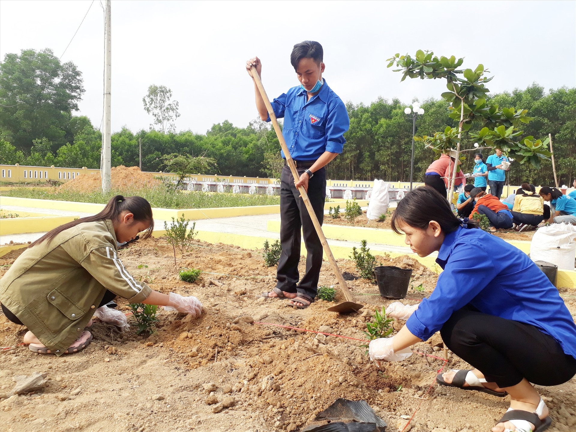 Đoàn viên thanh niên Quế Sơn trồng cây xanh tại Nghĩa trang liệt sĩ xã Quế An. Ảnh: T.P