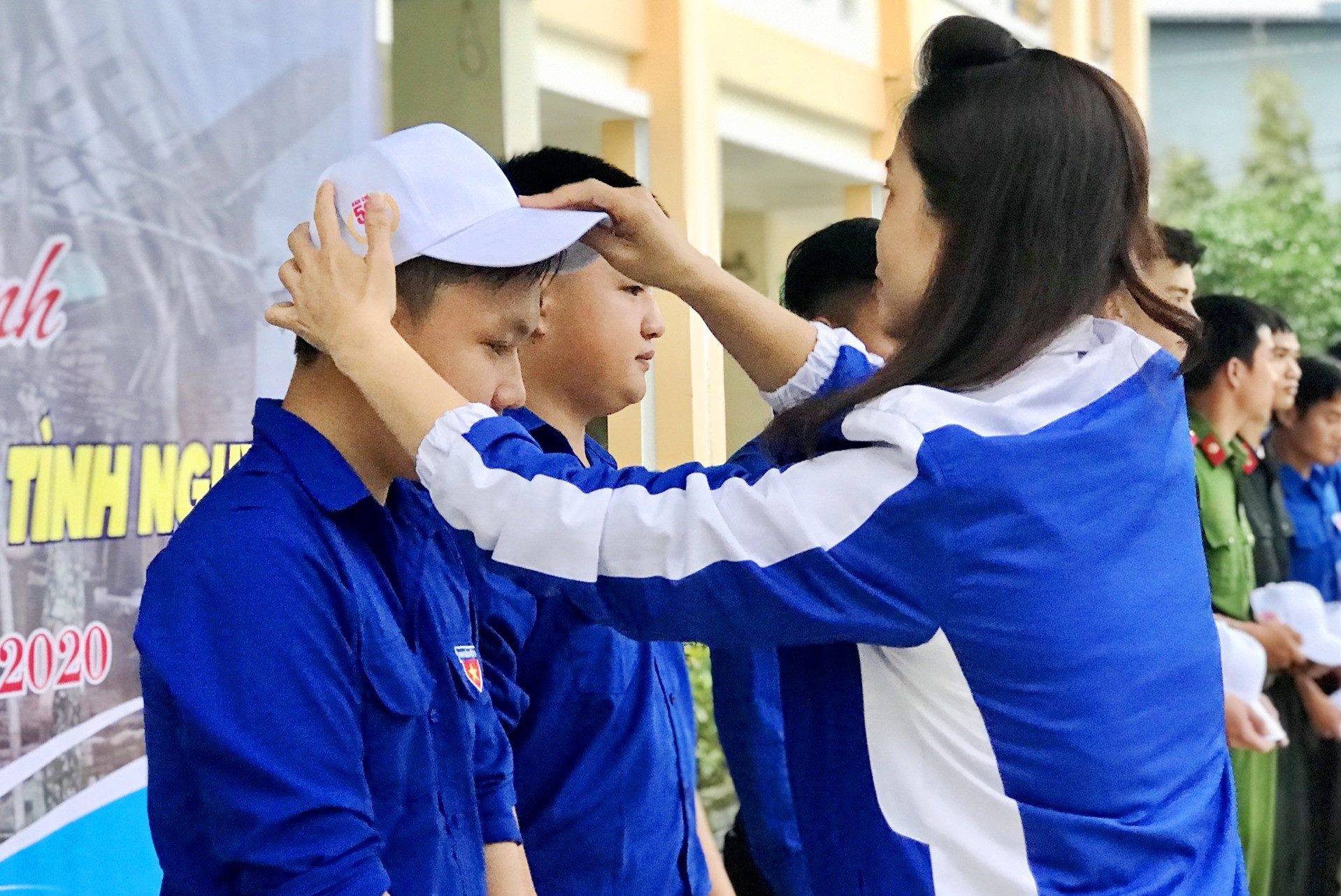 Bia thư Tỉnh đoàn Phạm Thị Thanh trao mũ cho thanh niên tình nguyện tham gia lễ xuất quân. Ảnh: VINH ANh