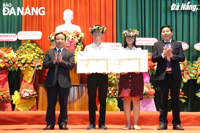 PGS, TS. Nguyễn Ngọc Vũ, Giám đốc Đại học Đà Nẵng (trái) và PGS, TS. Nguyễn Mạnh Toàn, Hiệu trưởng Trường Đại học Kinh tế (phải) khen thưởng 2 tân thủ khoa kỳ thi tuyển sinh năm 2020. Ảnh: NGỌC PHÚ