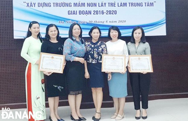 Hiệu trưởng Trường mầm non Bình Minh Nguyễn Quốc Thư Trâm (bìa phải) nhận giấy khen của Sở Giáo dục và Đào tạo về thành tích thực hiện chuyên đề xây dựng trường học lấy trẻ làm trung tâm. Ảnh: P.T