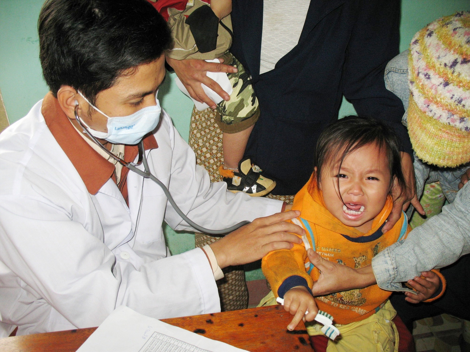Người dân đưa trẻ đi tiêm vắc xin tại một TYT xã. Ảnh: X.H