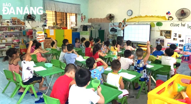 Cô giáo Trần Thị Lệ Phúc, giáo viên Trường mầm non 19-5 dạy trẻ nhận biết các con vật thông qua máy chiếu hình ảnh. Ảnh: NGỌC PHÚ