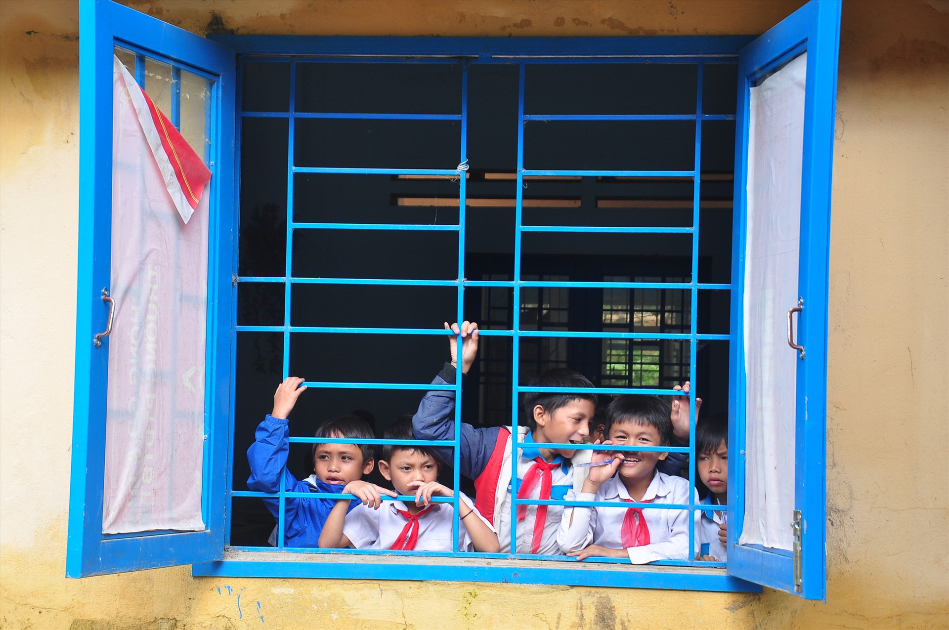 Trong khi đó, phía bên trong nhà trường, các em học sinh vui vẻ theo dõi hoạt động của lực lượng tình nguyện trong giờ nghỉ. Ảnh: VINH ANH