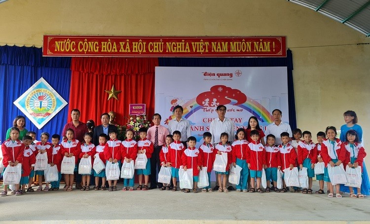 Lãnh đạo công ty Điện Quang tặng quà cho học sinh trường Tiểu học Duy Phước.