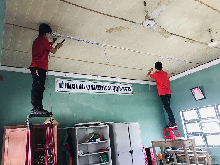Cán bộ kỹ thuật Công ty Điện Quang hỗ trợ lắp đặp hệ thống đèn chiếu sáng tại trường tiểu học Duy Phước.