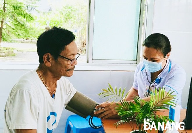 Phòng khám khang trang, sạch đẹp, cán bộ y tế tận tình là điểm cộng của Trạm Y tế xã Hòa Tiến, huyện Hòa Vang. TRONG ẢNH: Nhân viên y tế khám bệnh cho ông Lê Hữu Huy ((67 tuổi, trú thôn Lệ Sơn 2). Ảnh: Q.T