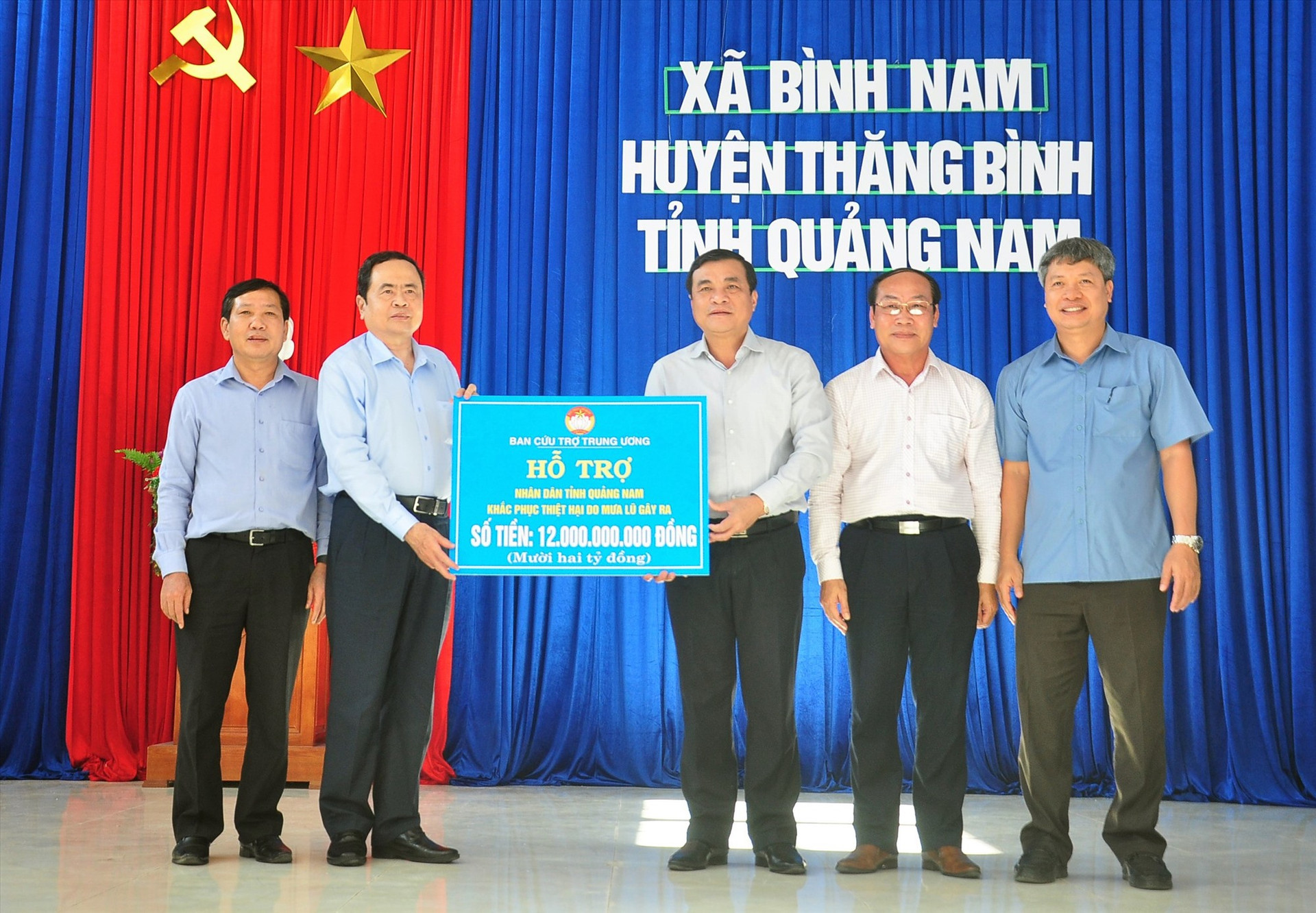 Chủ tịch Ủy ban Trung ương MTTQ Việt Nam Trần Thanh Mẫn (thứ hai bên trái) trao biểu trưng hỗ trợ 12 tỷ đồng cho Quảng Nam khắc phục bão lũ. Ảnh: VINH ANH