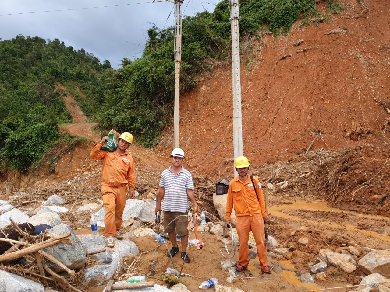 CBCNV Điện lực Hiệp Đức nỗ lực khắc phục hậu quả bão lũ, hoàn thành cấp điện lại phục vụ người dân xã Phước Lộc. Ảnh: KIÊN PHAN