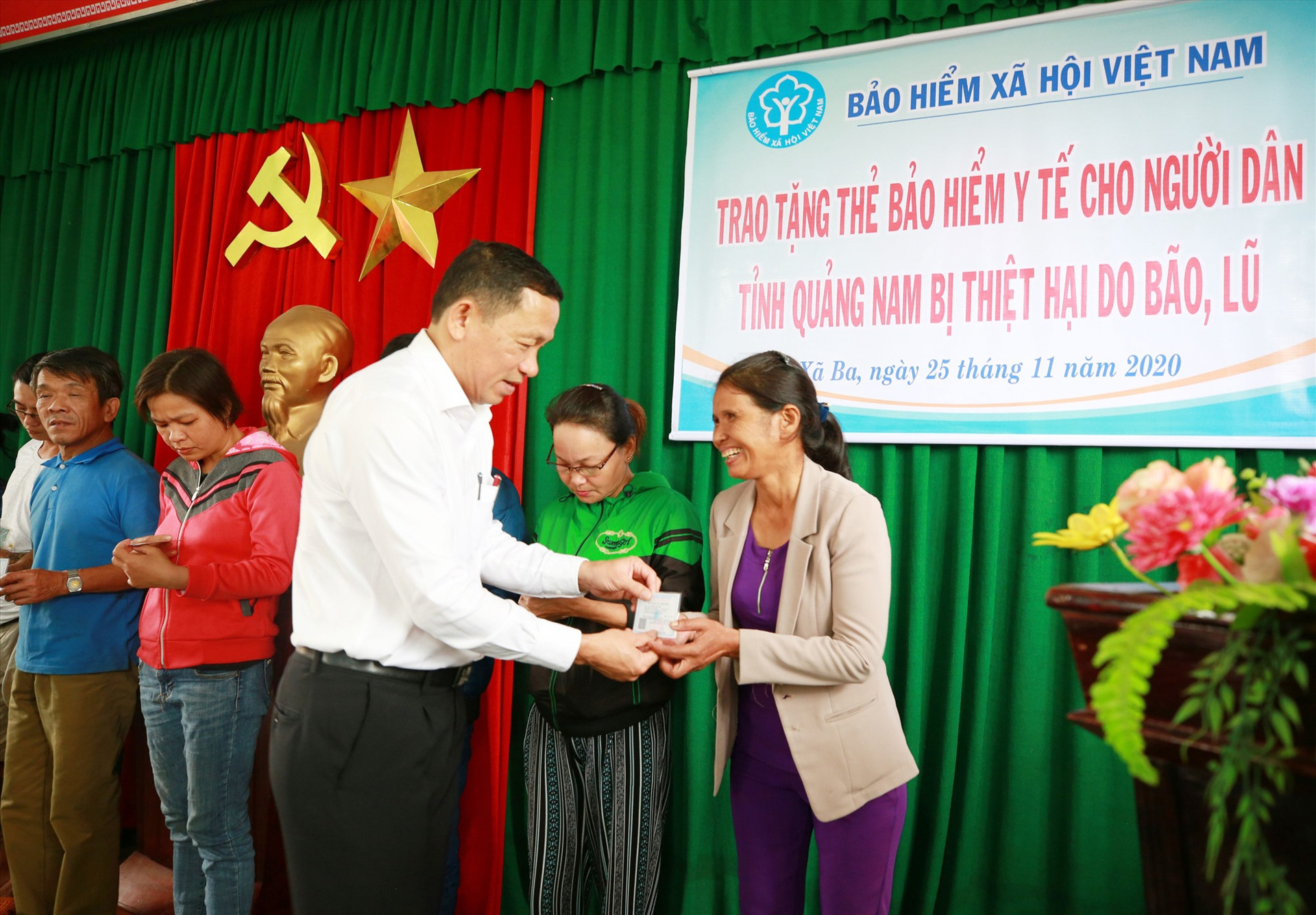 Giám đốc BHXH tỉnh Nguyễn Thanh Danh tặng thẻ BHYT cho người dân gặp khó khăn ở Đông Giang. Ảnh: D.L