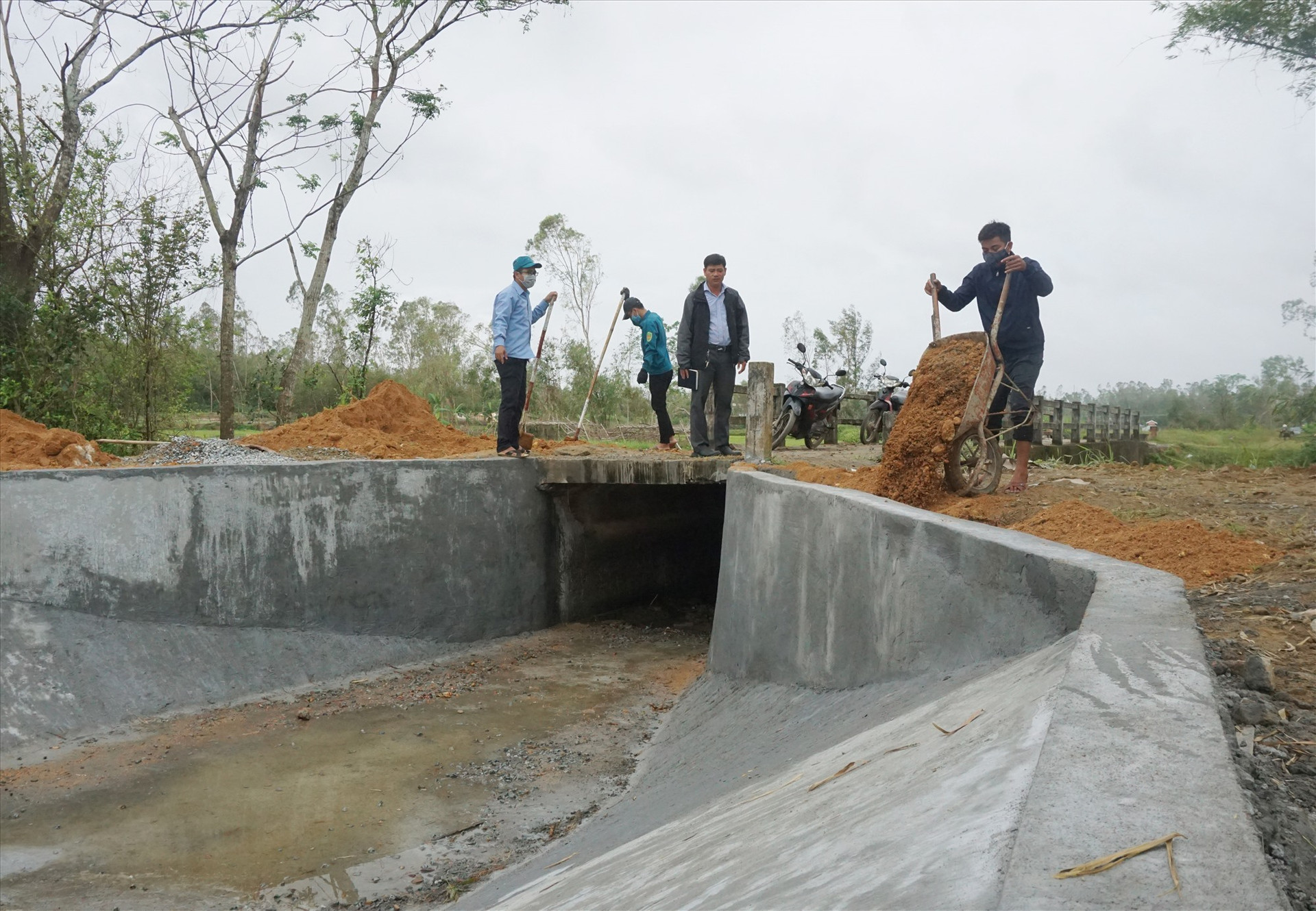 Chi nhánh Thủy lợi huyện Thăng Bình huy động lực lượng để khắc phục các điểm sạt lở kênh mương do mưa bão vừa qua. Ảnh: G.B