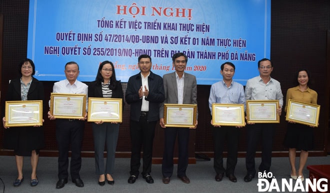 Phó Chủ tịch UBND thành phố Hồ Kỳ Minh (thứ năm, phải sang) trao bằng khen của UBND thành phố cho các tập thể, cá nhân có thành tích xuất sắc trong thực hiện Quyết định số 47/2014/QĐ-UBND.        Ảnh: HOÀNG HIỆP