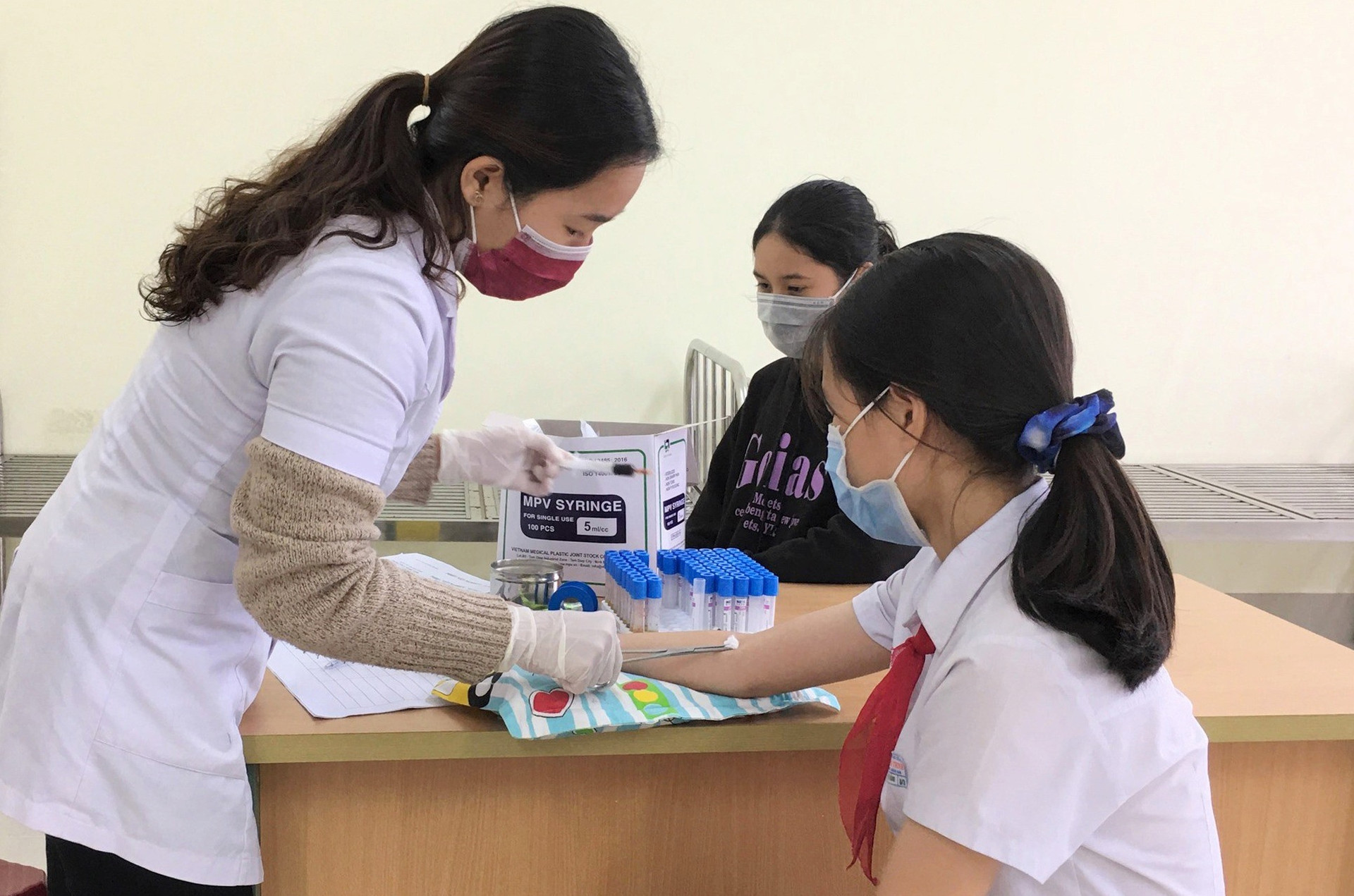 Cán bộ Trung tâm Y tế huyện Phú Ninh khám sức khỏe cho trẻ vị thành niên. Ảnh: HẢI CHÂU