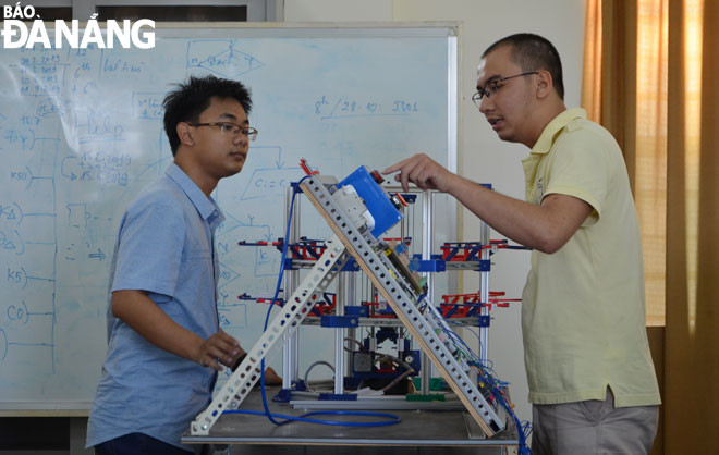 Giảng viên hướng dẫn sinh viên thực hành tại Phòng Thí nghiệm Tự động hóa, Trường Đại học Bách khoa - Đại học Đà Nẵng. (Ảnh chụp tháng 6-2020) Ảnh: NGỌC PHÚ