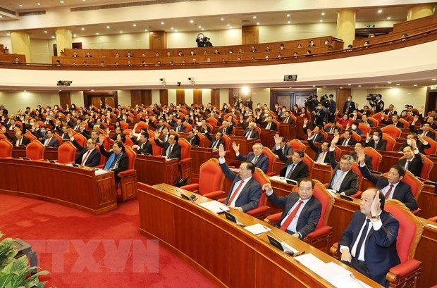 Các đồng chí lãnh đạo Đảng, Nhà nước và các đại biểu biểu quyết thông qua chương trình Hội nghị. (Ảnh: Trí Dũng/TTXVN)