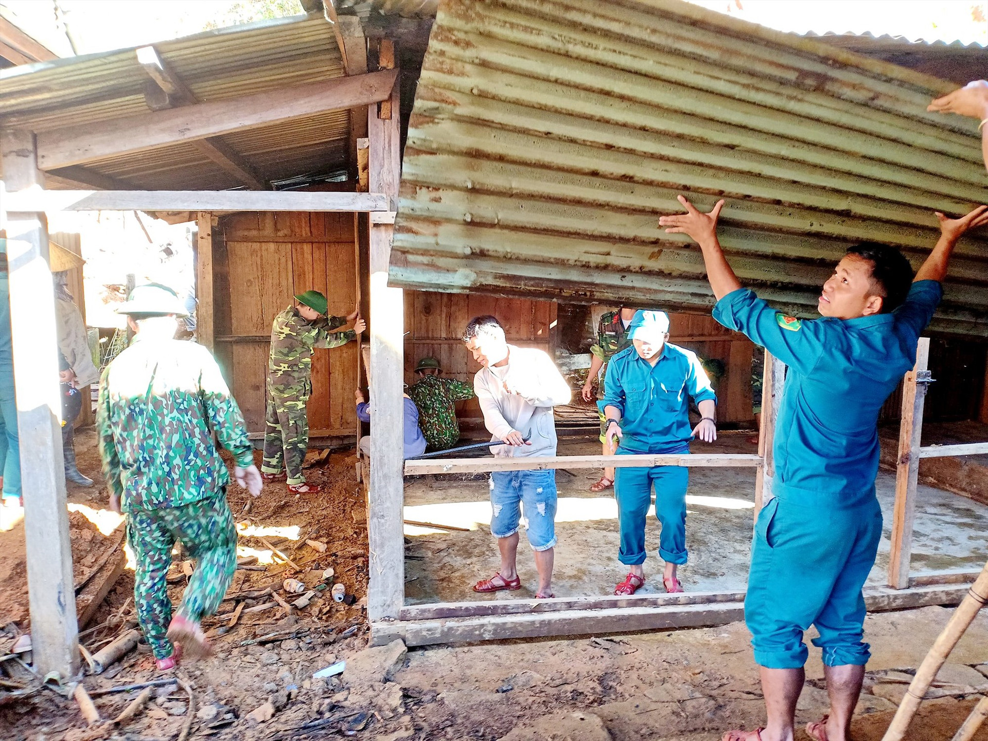 Bộ đội và lực lượng dân quân huyện Tây Giang giúp người dân sửa chữa nhà cửa sau mưa lũ.