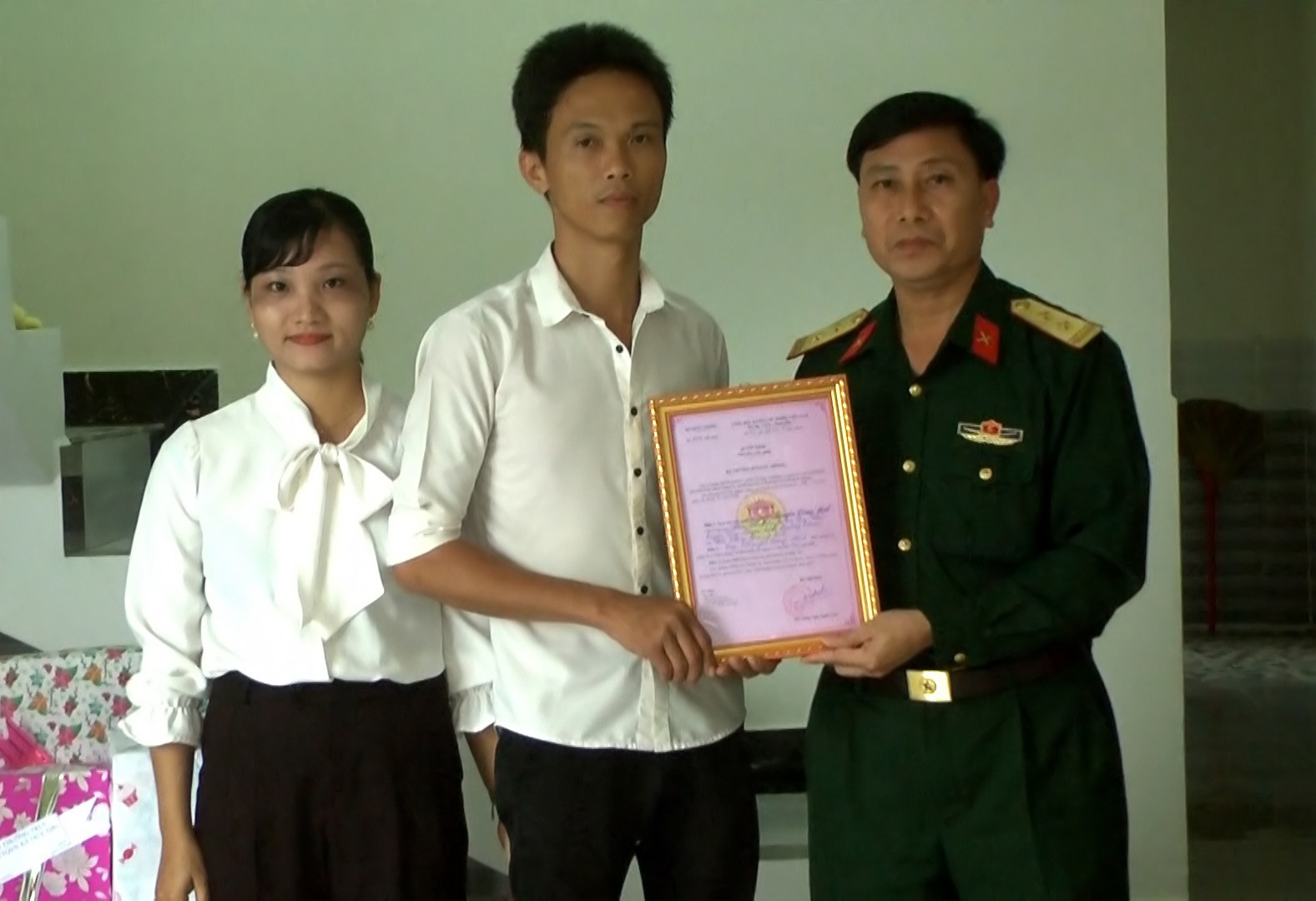 Trao quyết định của Bộ Quốc phòng về hỗ trợ xây dựng nhà tình nghĩa cho thương binh Nguyễn Công Hát.    Ảnh: T.P