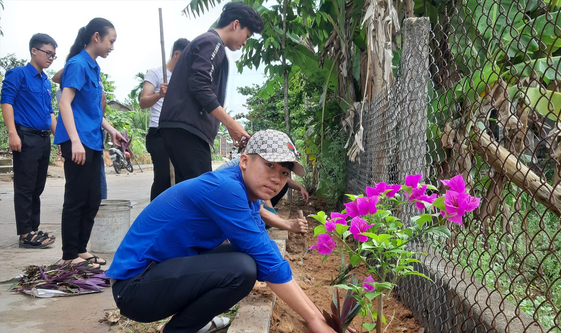 Người dân thôn Phú Bông (Duy Trinh, Duy Xuyên) ra quân trồng hoa thay thế cỏ dại trên các tuyến đường. Ảnh: HOÀI NHI