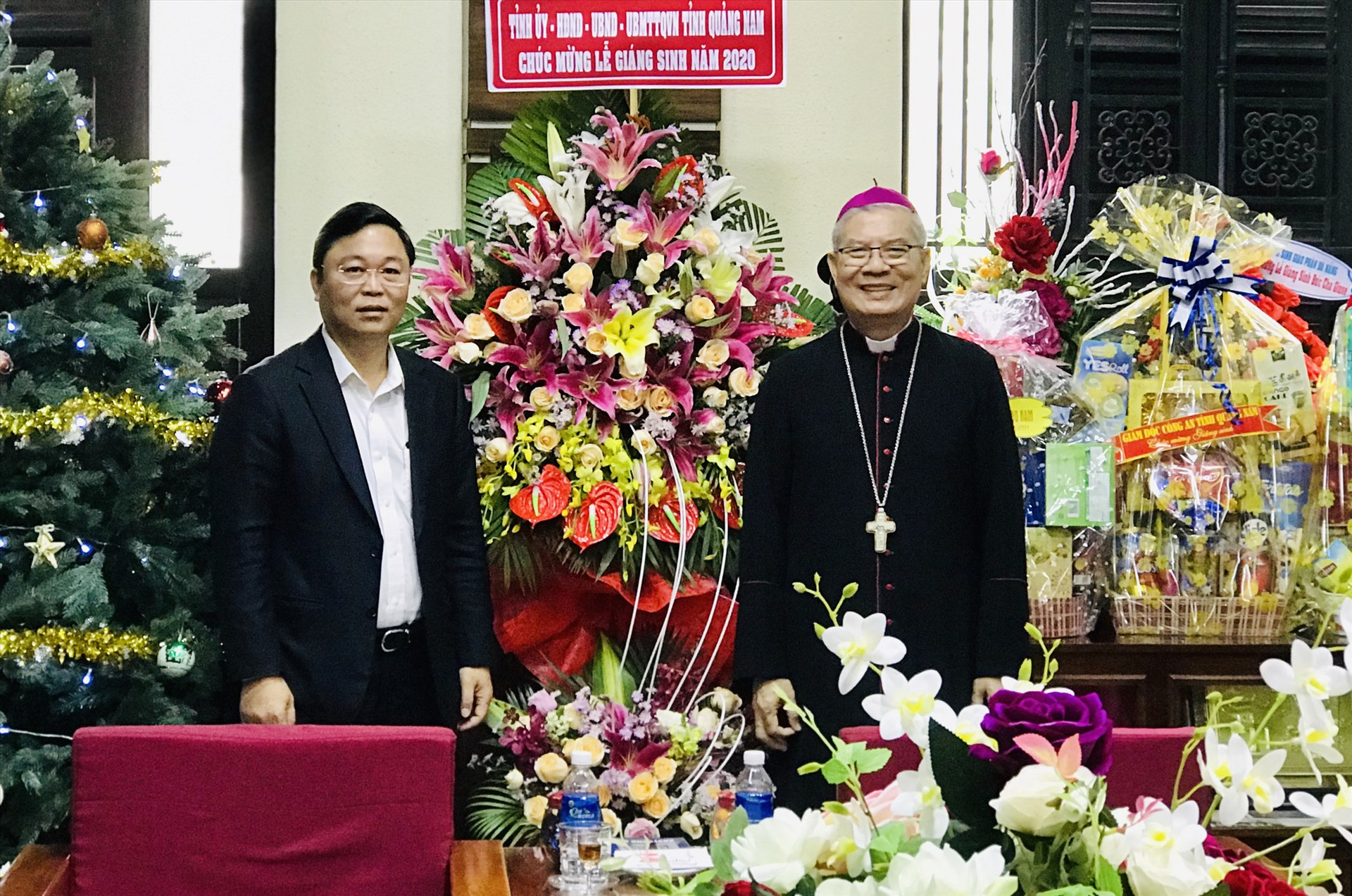 Chủ tịch UBND tỉnh Lê Trí Thanh tặng lẵng hoa chúc mừng Giáng sinh đến Giám mục Đặng Đức Ngân. Ảnh: H.S