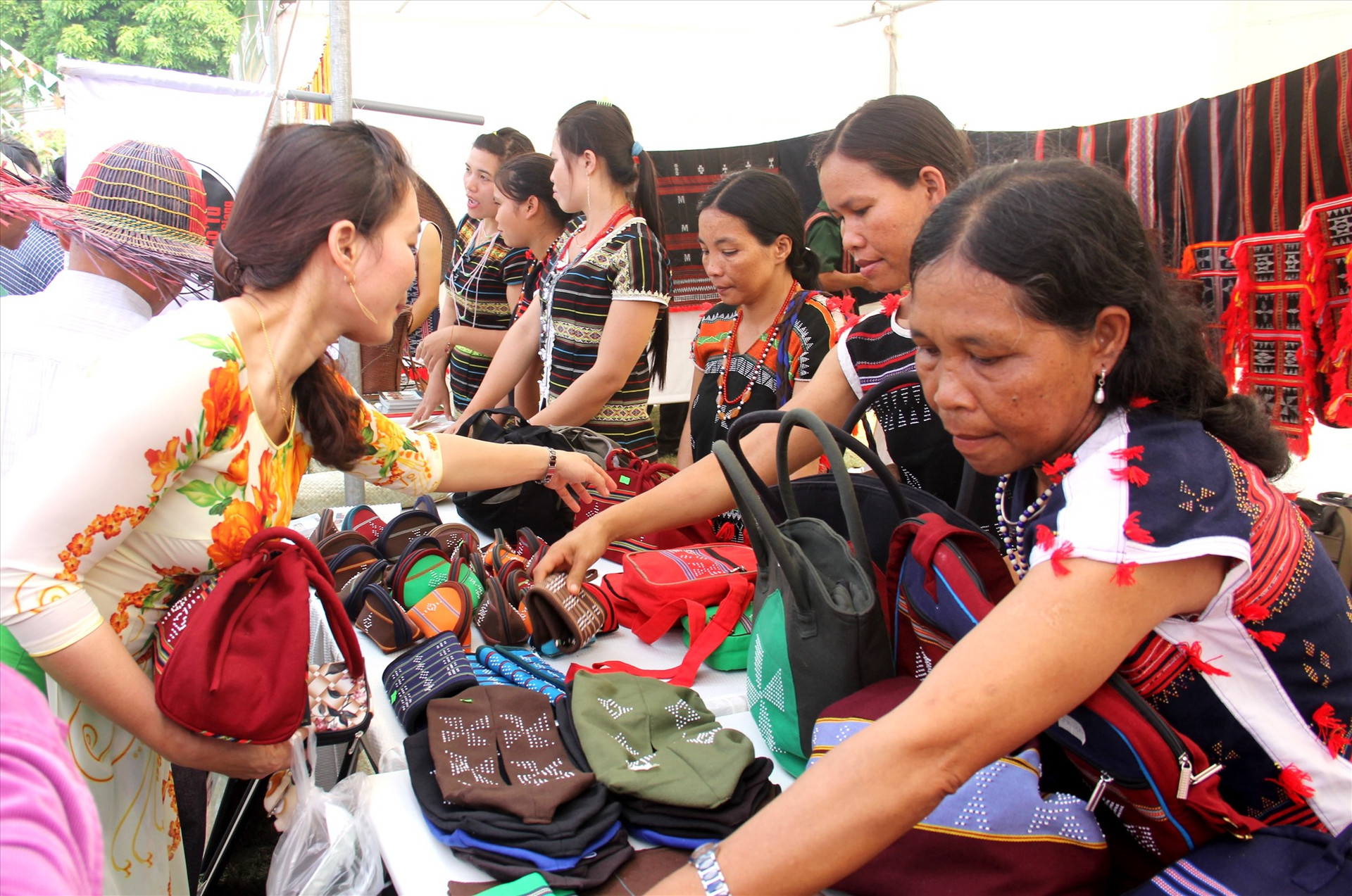 Các hội viên Hợp tác xã Dệt thổ cẩm Cơ Tu Za Ra giới thiệu sản phẩm túi Ađhir cho khách tại hội chợ triển lãm. Ảnh: ĐĂNG NGUYÊN