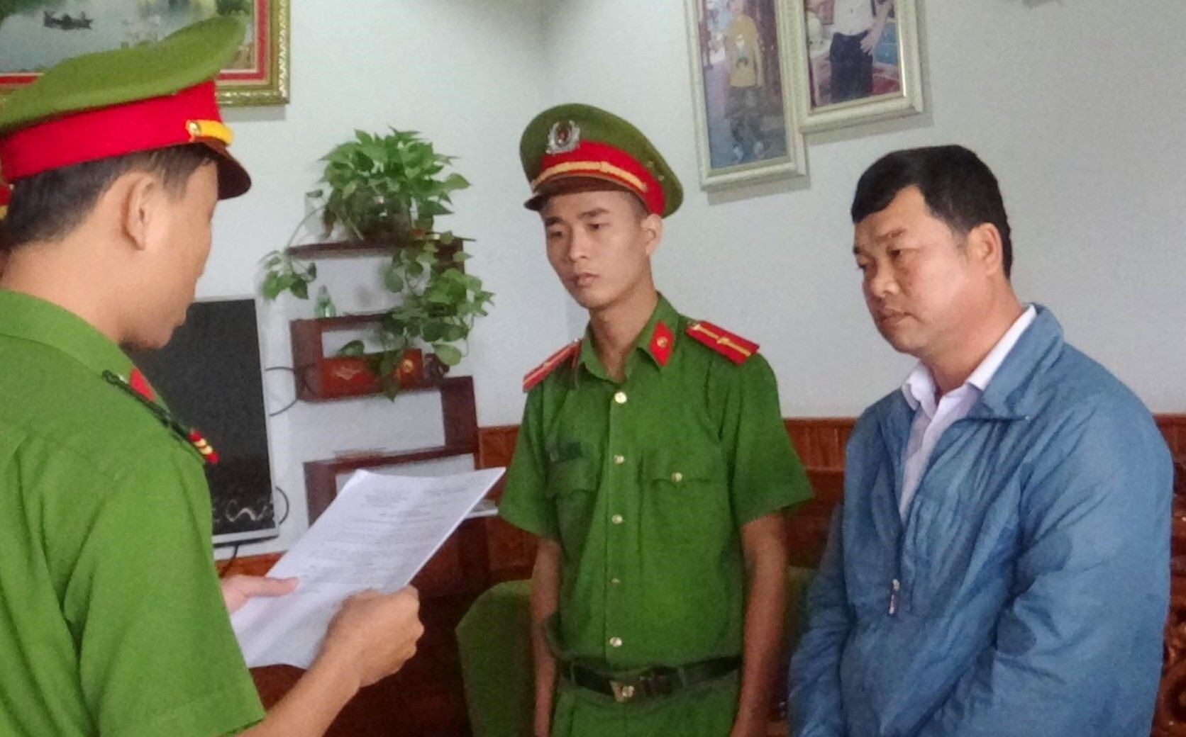 Cơ quan Cảnh sát điều tra Công an huyện Duy Xuyên thi hành các quyết định khởi tố bị can, bắt tạm giam đối với Phạm Đắc Thành ( áo xanh)