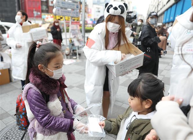 Các tình nguyện viên phát khẩu trang miễn phí cho người dân tại Tokyo, Nhật Bản. Ảnh: THX/TTXVN