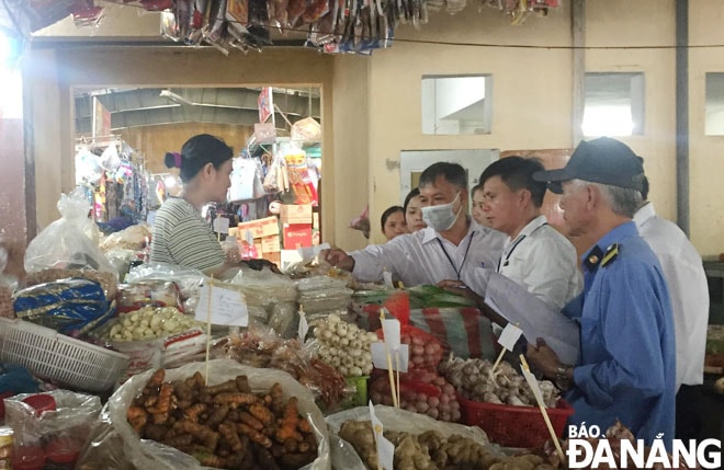 Lực lượng chức năng kiểm tra việc bảo đảm an toàn thực phẩm tại chợ Phước Mỹ. Ảnh: THÀNH LÂN