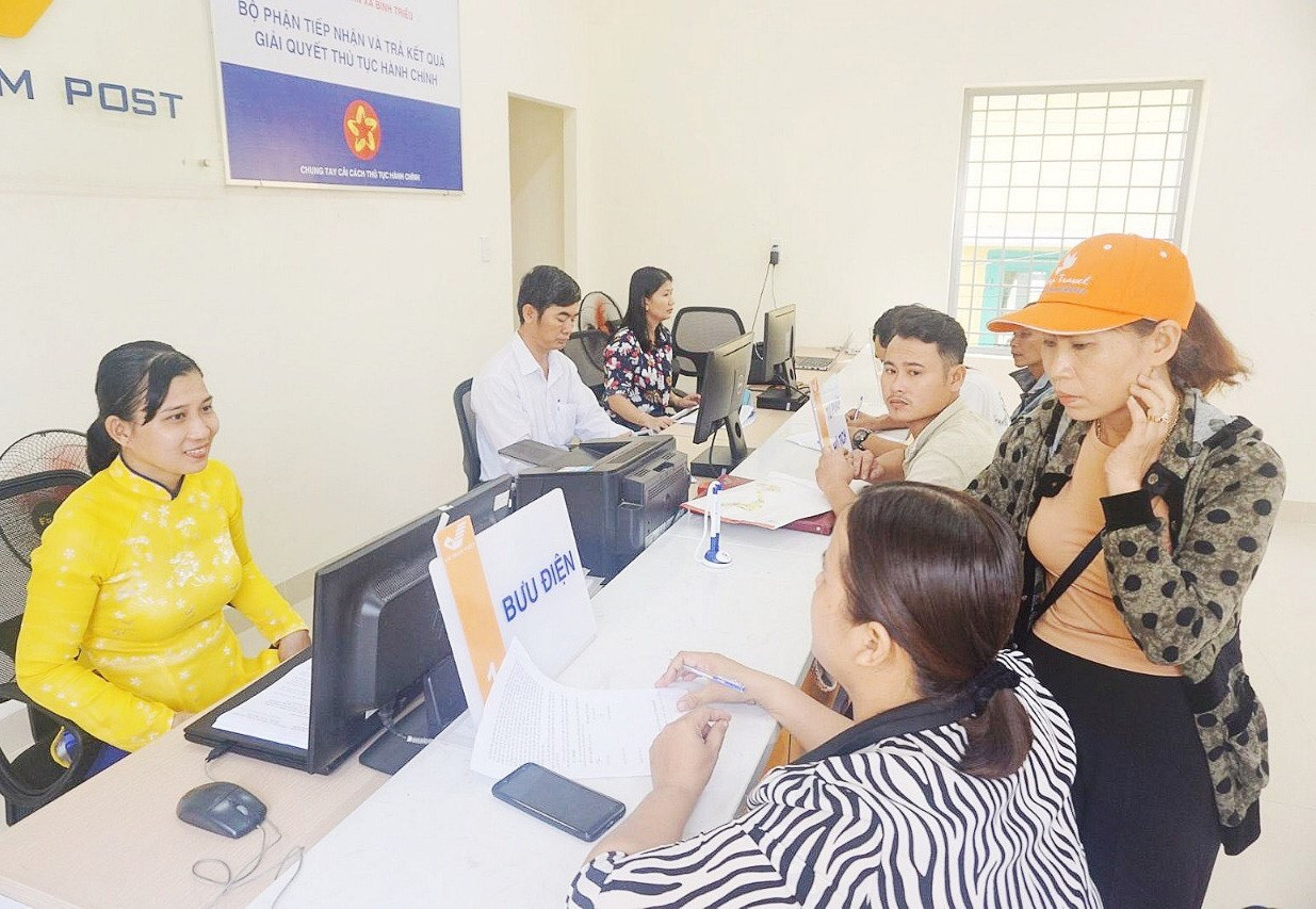 Người dân làm thủ tục hành chính tại Bưu điện xã Bình Triều, huyện Thăng Bình. Ảnh: B.Đ