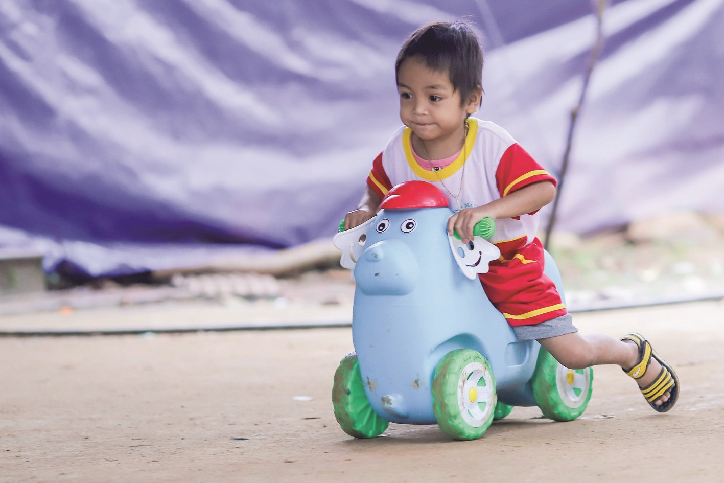 Em Hồ Quang Minh Hoài, 4 tuổi, chơi trong khu vực sân trường mầm non ở nóc ông Đề. Trong thảm họa sạt lở núi, mẹ và em của Hoài đều gặp bất hạnh.