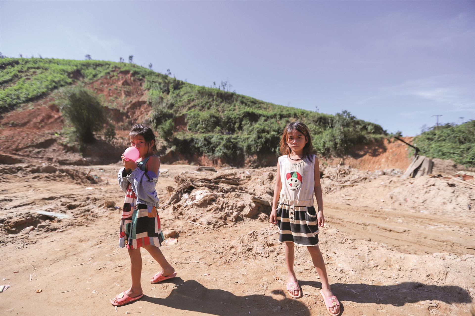 Những đứa trẻ ở xã Phước Kim đứng trên nền đất vốn là nhà mình.