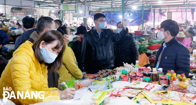Đoàn kiểm tra liên ngành quận Liên Chiểu lấy mẫu, test nhanh phẩm màu trong ớt màu bày bán tại quầy hàng thực phẩm khô, gia vị (lô 66, khu C, chợ Hòa Khánh) của bà Phạm Thị Hồi vào sáng 13-1 và có kết quả âm tính. Ảnh: M.HIỀN