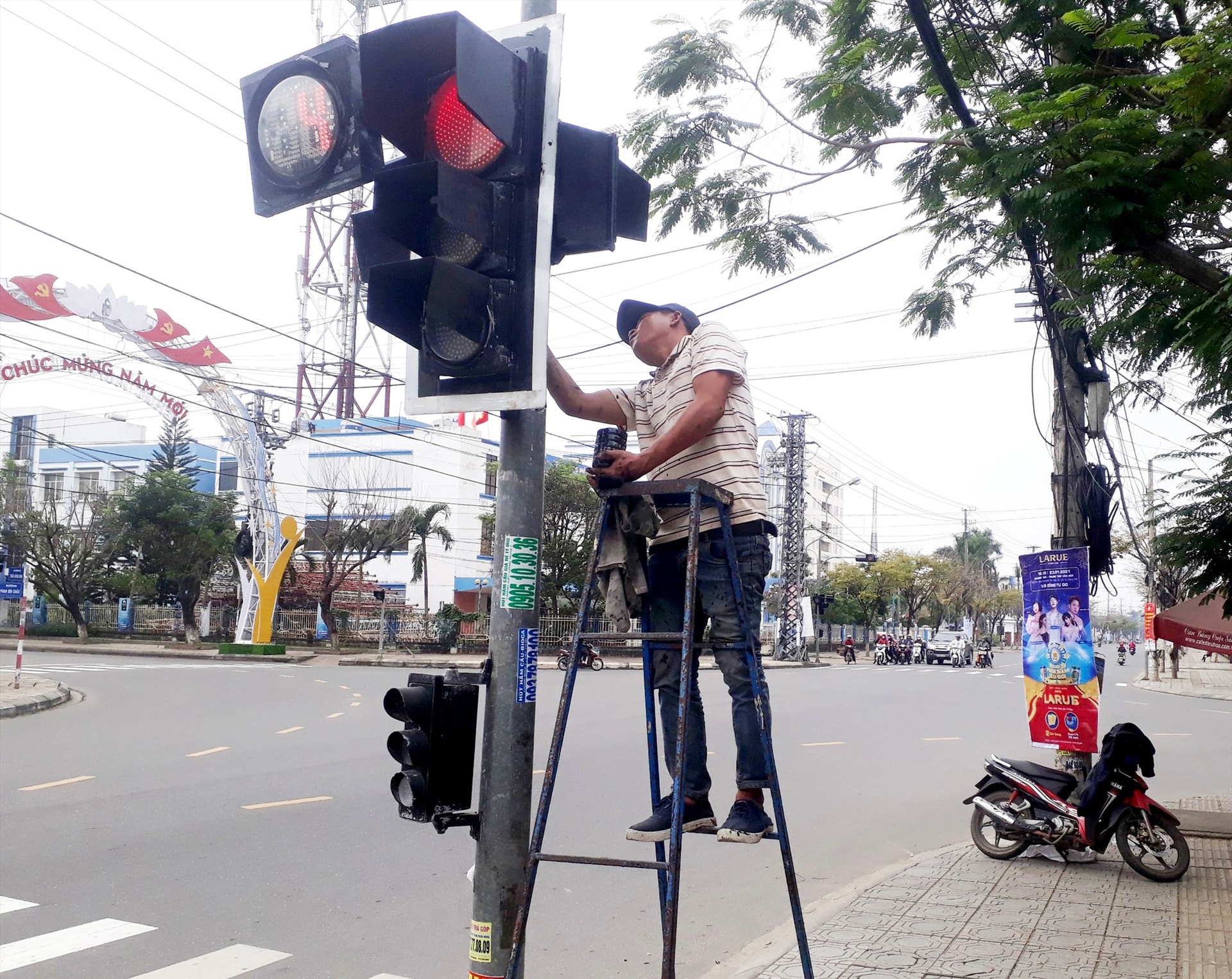 Vệ sinh, bảo trì đèn tín hiệu điều khiển giao thông trên đường Phan Bội Châu (Tam Kỳ) để đảm bảo phục vụ tết. Ảnh: CÔNG TÚ