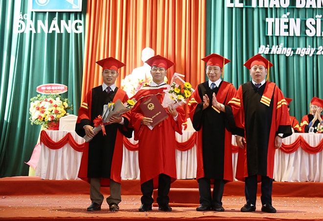 PGS.TS. Lê Thành Bắc (thứ 2 bên phải), Phó Giám đốc Đại học Đà Nẵng và PGS.TS. Nguyễn Mạnh Toàn (ngoài cùng bên phải) ,Trường Đại học Kinh trao bằng tiến sĩ cho các cá nhân. Ảnh: NGỌC PHÚ